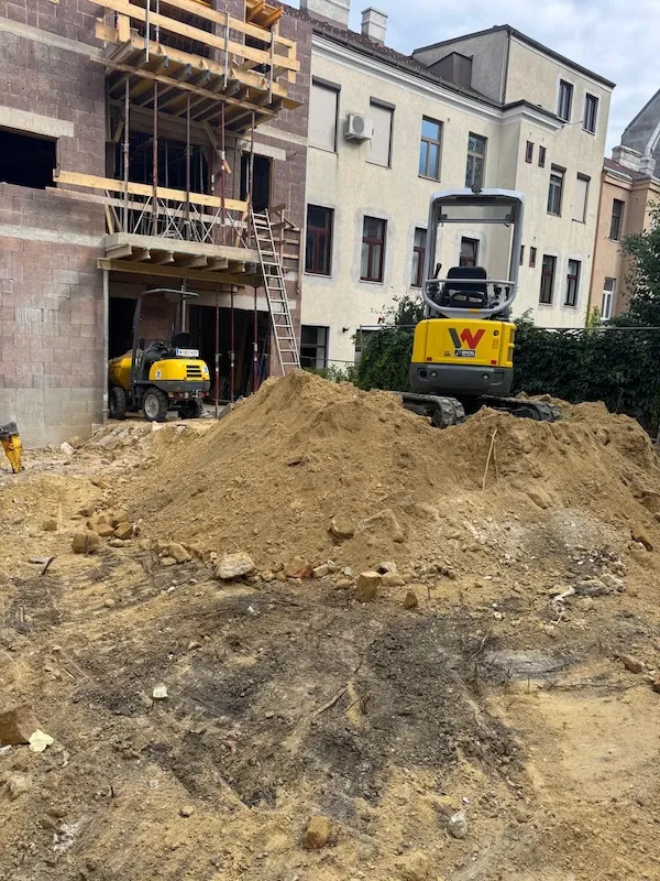 baustelle mit baggern und rohbau eines mehrfamilienhauses in der stadt