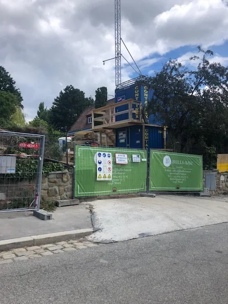 baustelle mit containern kran und sicherheitsabsperrung an der straße