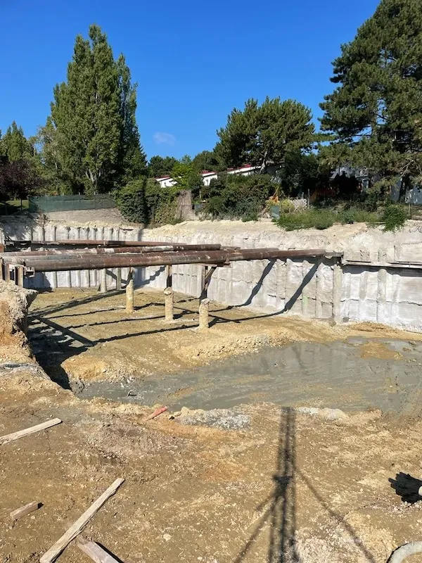 tiefbau baugrube mit stahlträgern und betonpfählen auf der baustelle